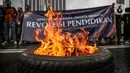 Massa yang tergabung dalam Gerakan Mahasiswa Jakarta Bersatu membakar ban saat unjuk rasa di depan gedung Kementerian Pendidikan dan Kebudayaan, Jakarta, Kamis (2/7/2020). Mereka menuntut adanya keringanan uang tunggal kuliah (UKT) sebesar 50 persen di tengah pandemi. (Liputan6.com/Faizal Fanani)