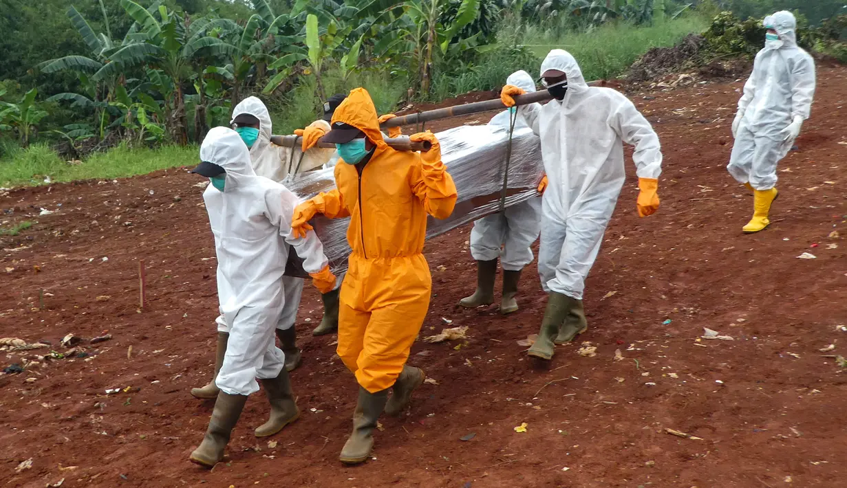 Petugas membawa peti jenazah berisi korban virus corona COVID-19 ke sebuah pemakaman di Jakarta, Rabu (15/4/2020). Hingga sore ini, jumlah kasus COVID-19 di Indonesia sebanyak 5.136 positif, 446 sembuh, dan 469 meninggal dunia. (Bay ISMOYO/AFP)