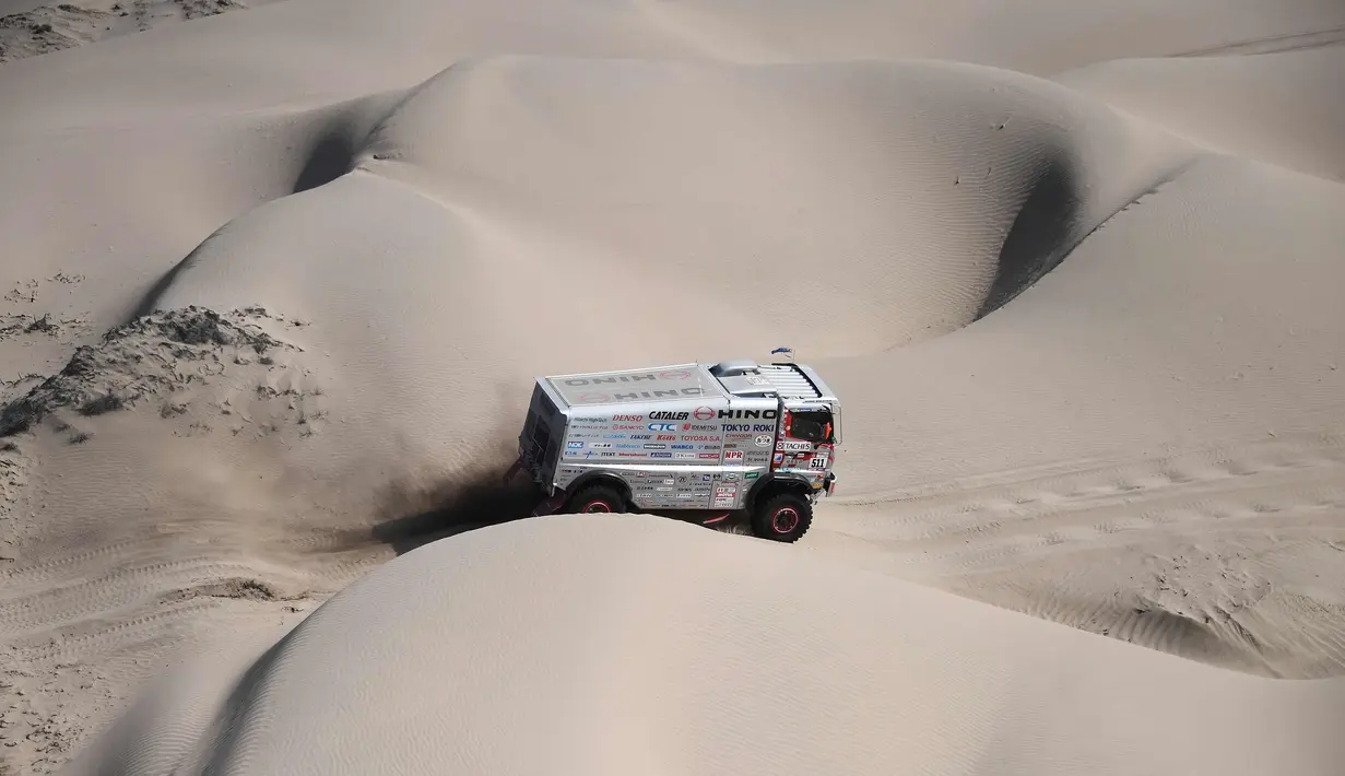 Putra Yoshimasa Sugawara, Teruhito Sugawara dan Mitsugu Takahashi saat bersaing selama Tahap 10 Dakar 2018 antara Salta dan Belen, Argentina, (16/1). Hino Team Sugawara berhasil finish kedua belas untuk kelas truk kategori umum. (AFP Photo/Franck Fife)