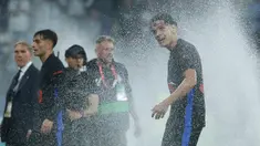 Pemain Barcelona, Hector Fort, menikmati siraman air dari lapangan usai mengunci gelar juara LaLiga 2024/2025 setelah mengalahkan Espanyol pada pertandingan ke-36 di RCDE Stadium, Jumat dini hari WIB (16/5/2025). (AP Photo/Joan Monfort)