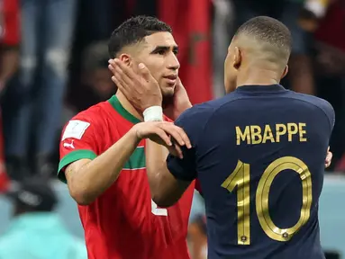 Bek Maroko Achraf Hakimi dihibur oleh penyerang Prancis Kylian Mbappe usai pertandingan semifinal Piala Dunia 2022 di Stadion Al-Bayt di Al Khor, Doha, Kamis (15/12/2022). Maroko gagal melaju ke final Piala Dunia 2022 Qatar setelah kalah dari Prancis dengan skor 2-0. (AFP/Karim Jaafar)
