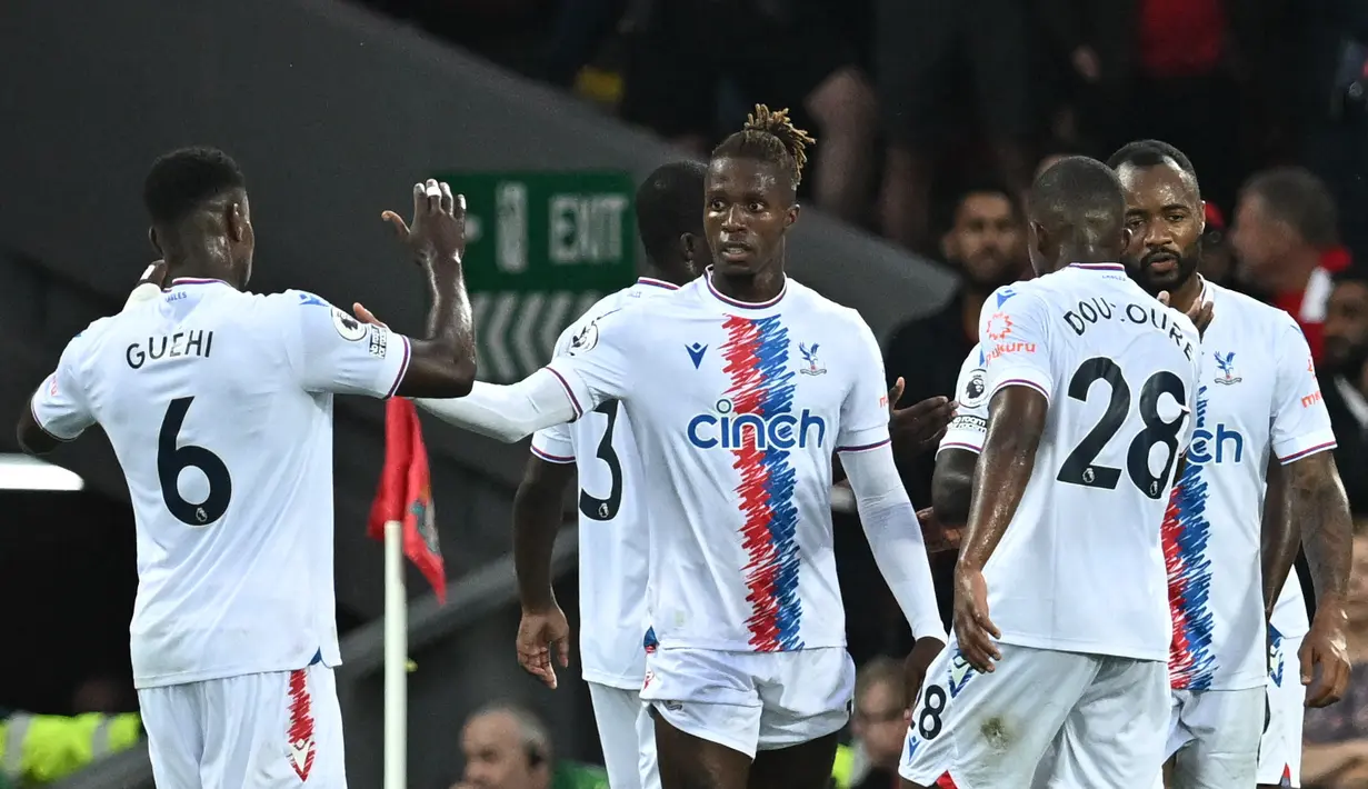 Penyerang  Crystal Palace, Wilfried Zaha (tengah) berselebrasi dengan rekan satu timnya usai mencetak gol ke gawang Liverpool pada pertandingan Liga Inggris di stadion Anfield, di Liverpool, Inggris (16/8/2022). Liverpool bermain imbang atas Crystal Palace 1-1. (AFP/Paul Ellis)