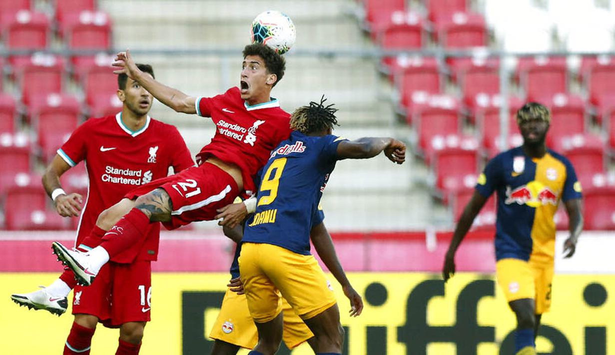 Pemain Liverpool, Kostas Tsimikas, berebut bola dengan pemain RB Salzburg, Chukwubuike Adamu, pada laga persahabatan di Stadion Red Bull Arena, Salzburg, Selasa (25/8/2020). Kedua tim bermain imbang dengan skor 2-2. (AP Photo/Matthias Schrader)