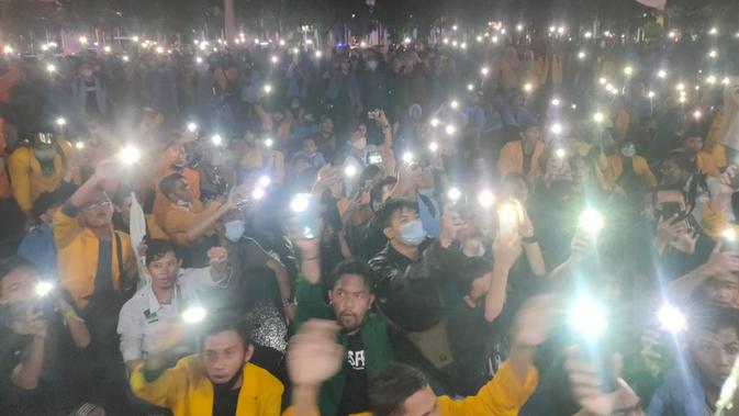 Para mahasiswa kompak menghidupkan lampu ponselnya, saat menggelar unjuk rasa di depan kantor Gubernur Sumsel di Palembang (Liputan6.com / Nefri Inge)