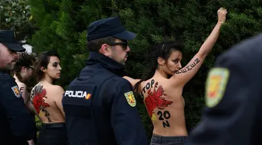 Polisi Spanyol menahan sejumlah aktivis Femen yang melakukan aksi telanjang dada memprotes penggalian makam diktator Spanyol Francisco Franco selama pertemuan tahunan di Madrid, Spanyol (24/11/2019). Aksi ini sekaligus memperingati kematian ke-44 Francisco Franco. (AFP/Oscar Del Pozo)