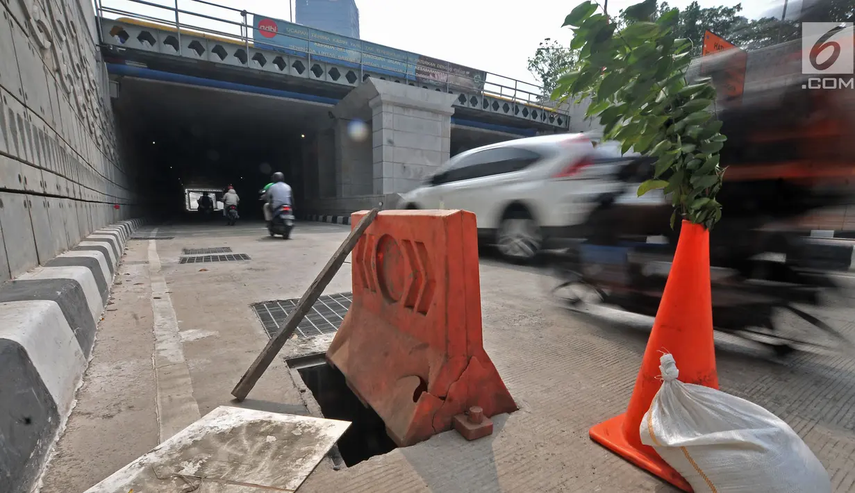 Pembatas jalan berwarna oranye diletakkan dekat penutup lubang saluran air yang hilang di Underpass Mampang-Kuningan, Jakarta, Kamis (23/8). Cone block dan tanaman itu dipasang agar tidak ada pengendara yang kecelakaan. (Merdeka.com/Iqbal S. Nugroho)