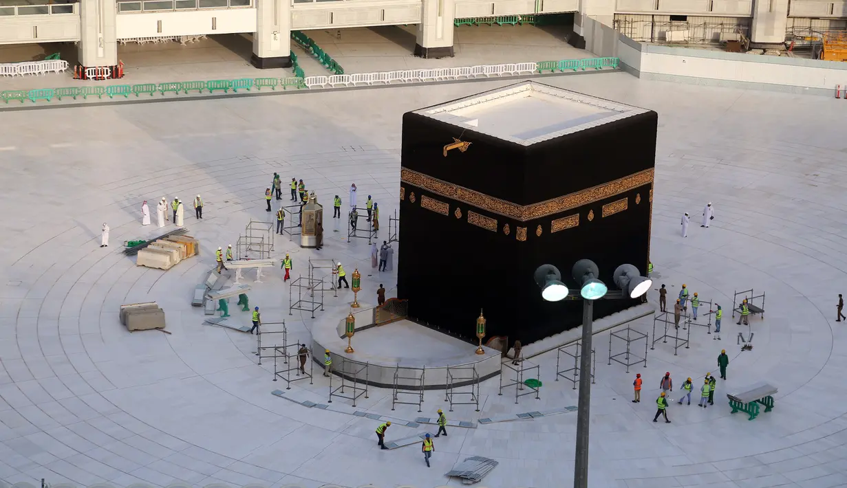 Sejumlah pekerja mengelilingi Kakbah di Masjidil Haram, Mekah, Arab Saudi, Kamis (5/3/2020). Penutupan Masjidil Haram dilaksanakan satu jam setelah salat isya pada hari Kamis (5/3) dan akan dibuka lagi satu jam sebelum salat subuh pada hari Jumat (6/3). (ABDEL GHANI BASHIR/AFP)