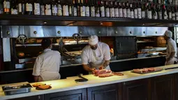 Seorang koki menyiapkan potongan daging untuk dimasak di dapur restoran Don Julio di lingkungan Palermo, Buenos Aires, Argentina, Kamis (20/5/2021). Penghentian ekspor daging sapi Argentina demi mengurangi kenaikan harga pada pasar dalam negeri yang terus melambung. (RONALDO SCHEMIDT/AFP)