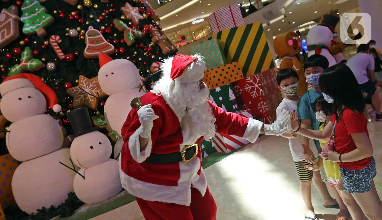 Petugas yang mengenakan kostum Sinterklas berinteraksi dengan anak-anak saat menghibur pengunjung di Senayan City Mall, Jakarta, Jumat (25/12/2020). Pengunjung bisa berswafoto dan menikmati momen Natal bersama keluarga dan orang terkasih dengan "Santa and Friend". (Liputan6.com/Herman Zakharia)