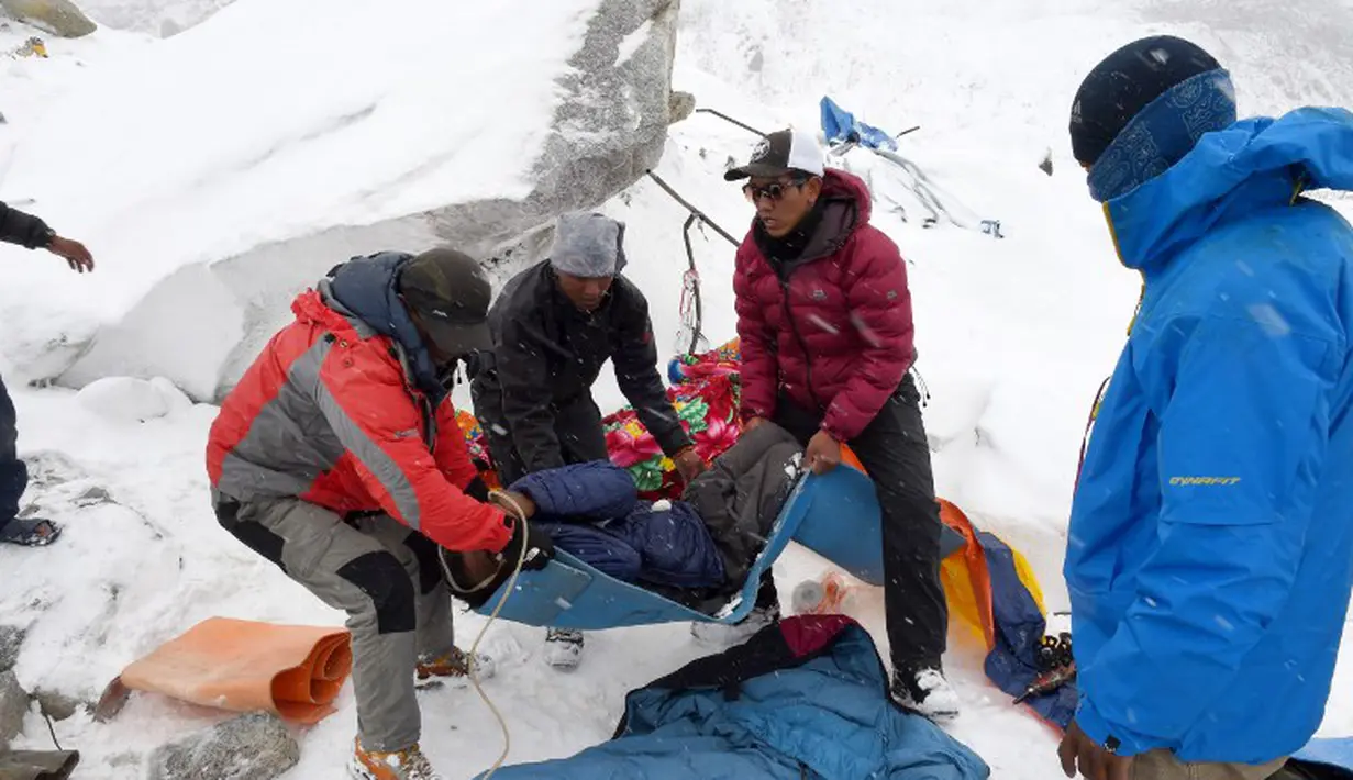 Sejumlah petugas memberikan pertolongan kepada para pendaki gunung yang menjadi korban akibat gempa berkekuatan 7.8 skala Richter yang melanda Nepal, Sabtu (25/4/2015). (AFP Photo/Roberto Schmidt)