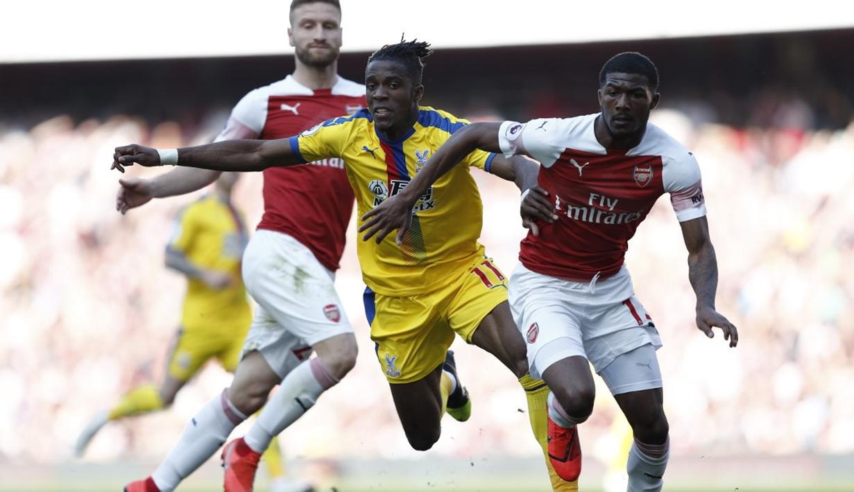 Aksi Wilfried Zaha yang kerap merepotkan pemain Arsenal pada laga lanjutan Premier League yang berlangsung di Stadion Emirates, Minggu (21/4). Arsenal kalah 2-3 kontra Crystal Palace. (AFP/Adrian Dennis)