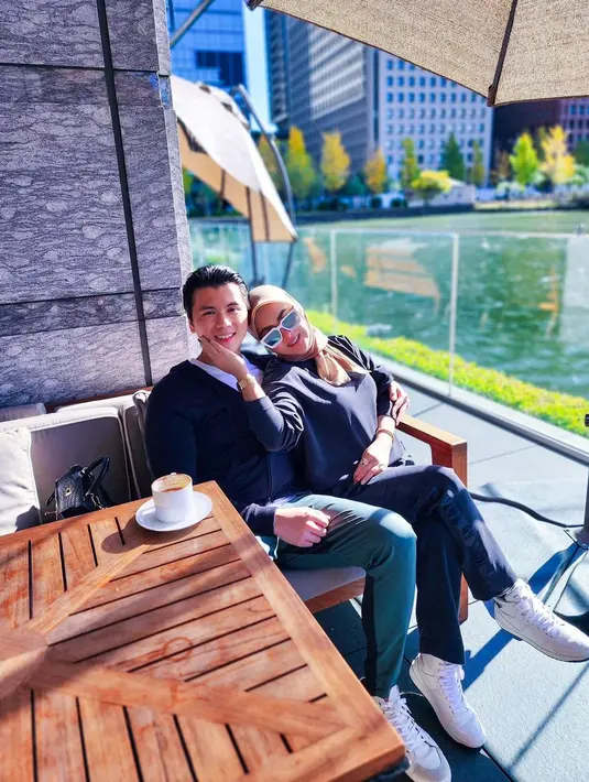 Menikmati sajian di pinggir danau, Syahrini dan Reino tampil serasi dalam balutan busana serba hitam. Syahrini tampil kasual dengan padu padan blus dan celana hitam, hijab krem dan tas Hermes. Sedangkan Reino memadukan jaket hitam, kaos, dan celana panjang. @princessyahrini.