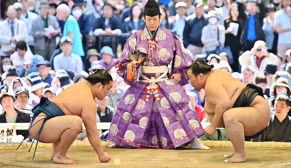Pegulat sumo bersiap untuk bertanding dalam turnamen Honozumo di Kuil Yasukuni, Tokyo, Jepang, 15 April 2019. Turnamen seremonial ini diikuti oleh para jawara sumo. (TRIBALLEAU CHARLY/AFP)