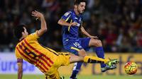 Gelandang Barcelona, Sergio Busquets (kiri), mencoba mengambil bola dari pemain Getafe, Pablo Sarabia (kanan), pada laga La Liga di Stadion Coliseum Alfonso Perez, Madrid, Sabtu (31/10/2015). (AFP PHOTO / Javier Soriano)
