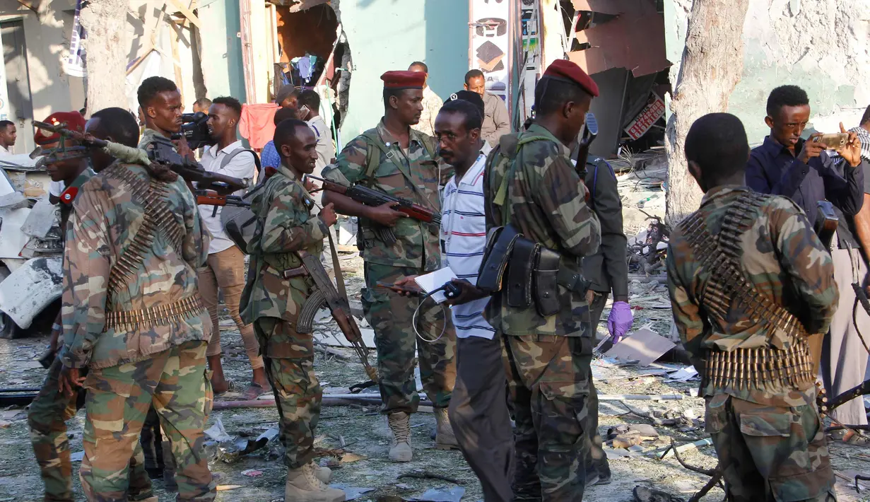 Pasukan keamanan berjaga di lokasi ledakan di luar Hotel Weheliye, Mogadishu, Somalia, (22/3). Mereka mengklaim telah menargetkan pertemuan pejabat pemerintah, tentara dan perwira intelijen. (AP Foto/Farah Abdi Warsameh)
