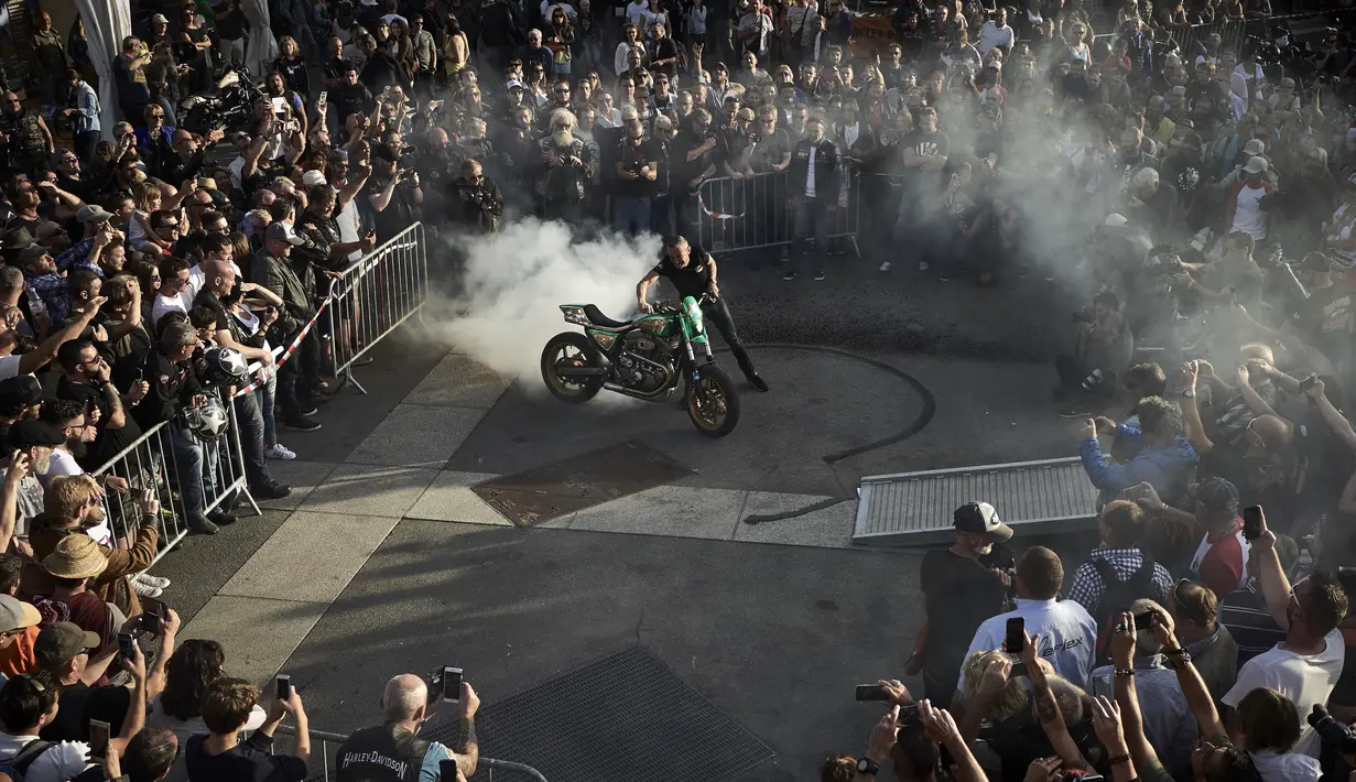 Penggemar sepeda motor gede (moge) menonton atraksi drifting saat acara 6th Morzine-Avoriaz Harley Days 2017, Morzine (15/7). (AFP Photo/Jean-Philippe Ksaizek)