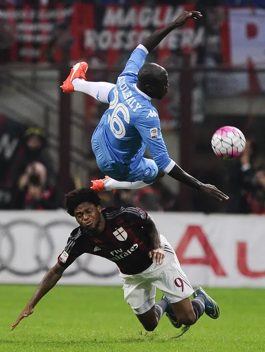 Penyerang AC Milan, Luiz Adriano (bawah) berebut bola dengan bek Napoli, kalidou koulibaly pada Lanjutan liga Italia di Stadion San Siro (4/10/2015). AC Milan Kalah telak atas Napoli dengan skor 0-4. (REUTERS/Giorgio Perottino)