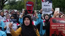 Mereka memprotes keterlibatan Indonesia dalam Board of Peace (BoP), sebuah badan internasional untuk rekonstruksi pascaperang di Gaza yang diusulkan oleh Presiden AS, Donald Trump. Tampak dalam foto, aktivis Muslim mengangkat poster dan meneriakkan slogan-slogan selama unjuk rasa dukungan untuk warga Palestina di Gaza, di depan Kedutaan Besar Amerika Serikat, Jakarta, Jumat 13 Februari 2026. (AP Photo/Achmad Ibrahim)
