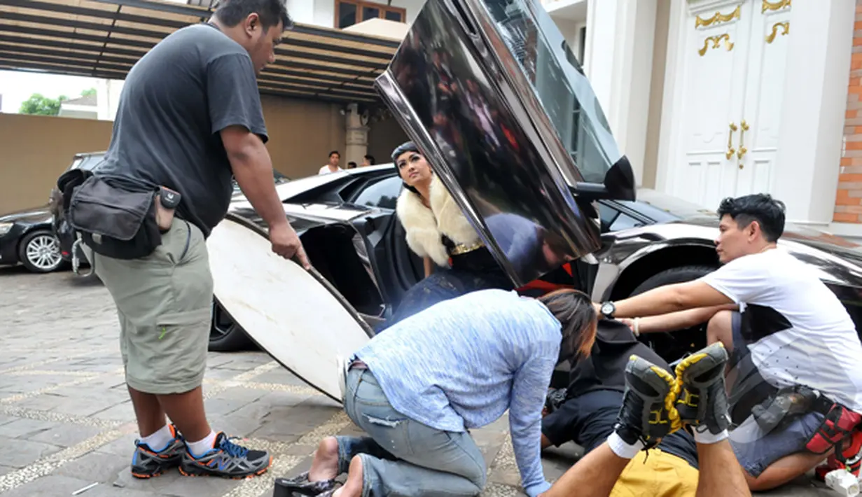 Julia Perez berakting keluar dari Lamborghini saat syuting video klip berjudul Lonely di kawasan Pondok Indah, Jakarta, Rabu (21/1/2014).(Liputan6.com/Panji Diksana)