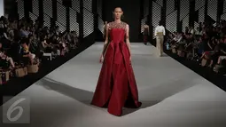 Model mengenakan busana rancangan Andreas Odang pada malam pembukaan Senayan City Fashion Nation ke-11, Kamis (6/4). Bertajuk La Memoire, Odang juga tidak segan bermain dengan koleksi kain khas Indonesia yaitu tenun. (Liputan6.com/Herman Zakharia)