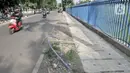 Kendaraan melintasi kabel proyek PLN yang terbengkalai di Jalan Jatinegara Kaum, Jakarta, Minggu (12/1/2020). Kurangnya pengawasan dalam penyelesaian proyek instalasi listrik bawah tanah PLN tersebut menyebabkan banyak kabel masih muncul di trotoar dan bahu jalan. (merdeka.com/Iqbal S. Nugroho)