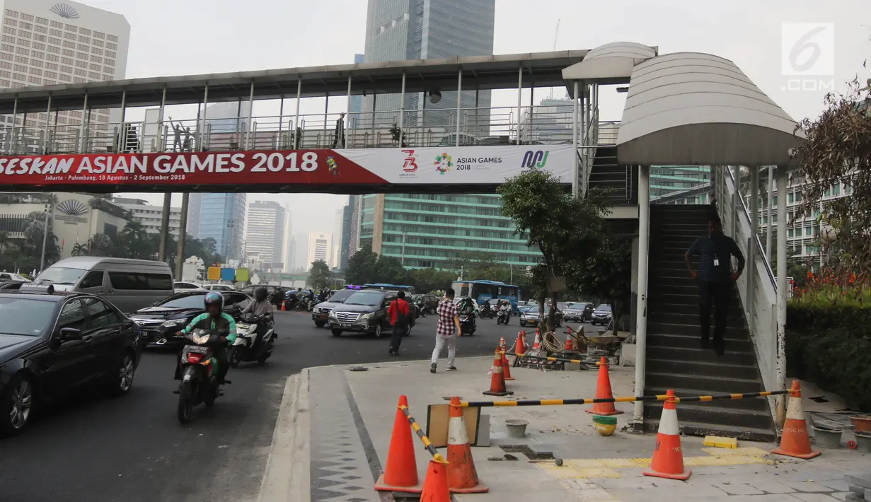 Pengendara melintas melintas di bawah jembatan penyeberangan orang (JPO) di Bundaran HI, Jakarta, Selasa (24/7). Pemprov DKI berencana merobohkan JPO tersebut karena menghalangi pandangan ke Patung Selamat Datang. (Liputan6.com/Arya Manggala)