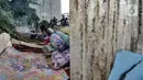 Seorang tunawisma memasak di dekat tempat tidurnya di kolong rel dwi ganda di kawasan Manggarai, Jakarta, Kamis (7/1/2021). Mereka yang terpaksa berprofesi sebagai pemulung memilih tinggal di kolong rel akibat ketimpangan sosial yang semakin tinggi di Ibu Kota. (merdeka.com/Iqbal S. Nugroho)