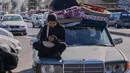 Seorang wanita pengungsi memeriksa ponselnya sambil menunggu untuk kembali ke desanya setelah pengumuman kesepakatan gencatan senjata awal antara Amerika Serikat dan Iran, di kota pelabuhan selatan Sidon, Lebanon, Senin 15 Juni 2026. (AP Photo/Mohammed Zaatari)
