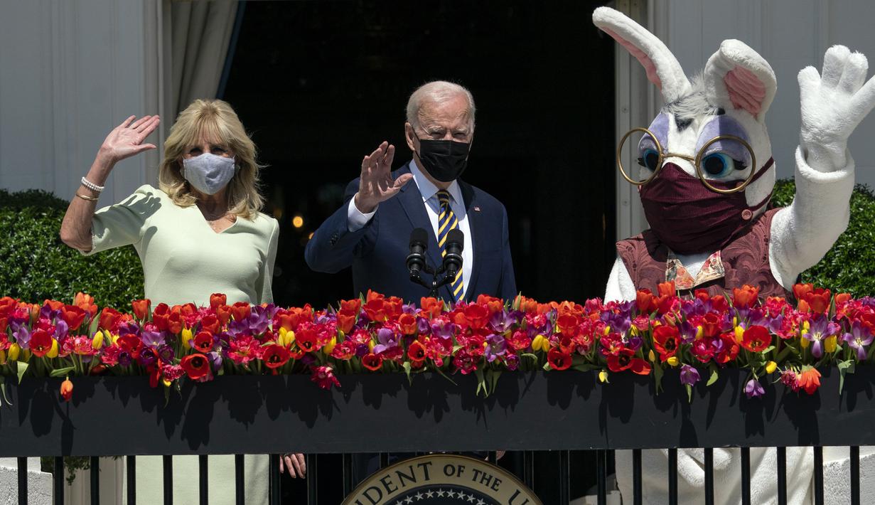 Presiden Joe Biden bersama Ibu Negara Jill Biden dan Kelinci Paskah melambaikan tangan dari balkon Ruang Biru, Gedung Putih, Washington, Amerika Serikat, Senin (5/4/2021). Gedung Putih kembali meniadakan tradisi Easter Egg Roll menyusul pandemi COVID-19 yang sedang berlangsung. (AP Photo/Evan Vucci)
