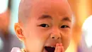 Ekspresi lucu biksu cilik saat ikut upacara Buddha Monks di kuil Jogye, Seoul, Rabu (19/4). Upacara ini digelar menjelang perayaan ulang tahun Buddha yang akan jatuh pada 3 Mei 2017 mendatang. (AFP PHOTO / JUNG Yeon-Je)