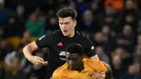 Pemain Wolverhampton Wanderers, Benny Ashley-Seal berebut bola dengan bek Manchester United, Harry Maguire pada babak ketiga Piala FA di Molineux, Sabtu (4/1/2020). Wolverhampton dan MU dipaksa untuk melakukan laga ulangan di Old Trafford usai bermain imbang tanpa gol. (AP/Rui Vieira)