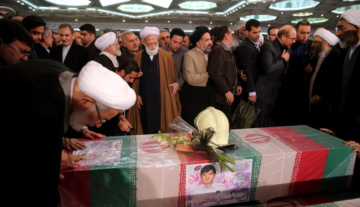 Warga Iran menggelar upacara penghormatan kepada 16 petugas pemadam kebakaran yang tewas dalam runtuhnya gedung yang terbakar pada 19 Januari, di Teheran, Iran, Senin (30/1). (AP Photo / Ebrahim Noroozi)