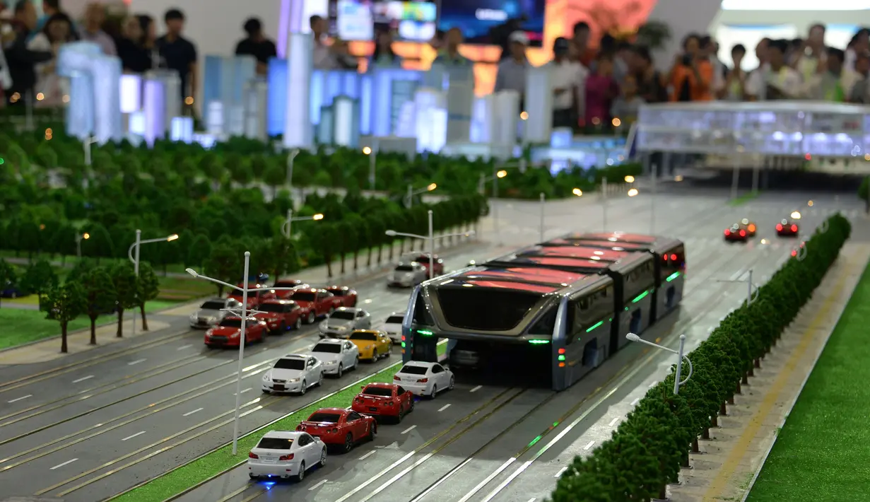 Model Bus yang mengangkangi jalan melawati mobil di sebuah pameran di Beijing, Cina, (19/5). Menurut perancangnya, Song Youzhiu, per tahun bus ini akan menghemat 800 ton bahan bakar dan mencegah hampir 2.500 ton emisi gas buang. REUTERS/Hu Qingming)