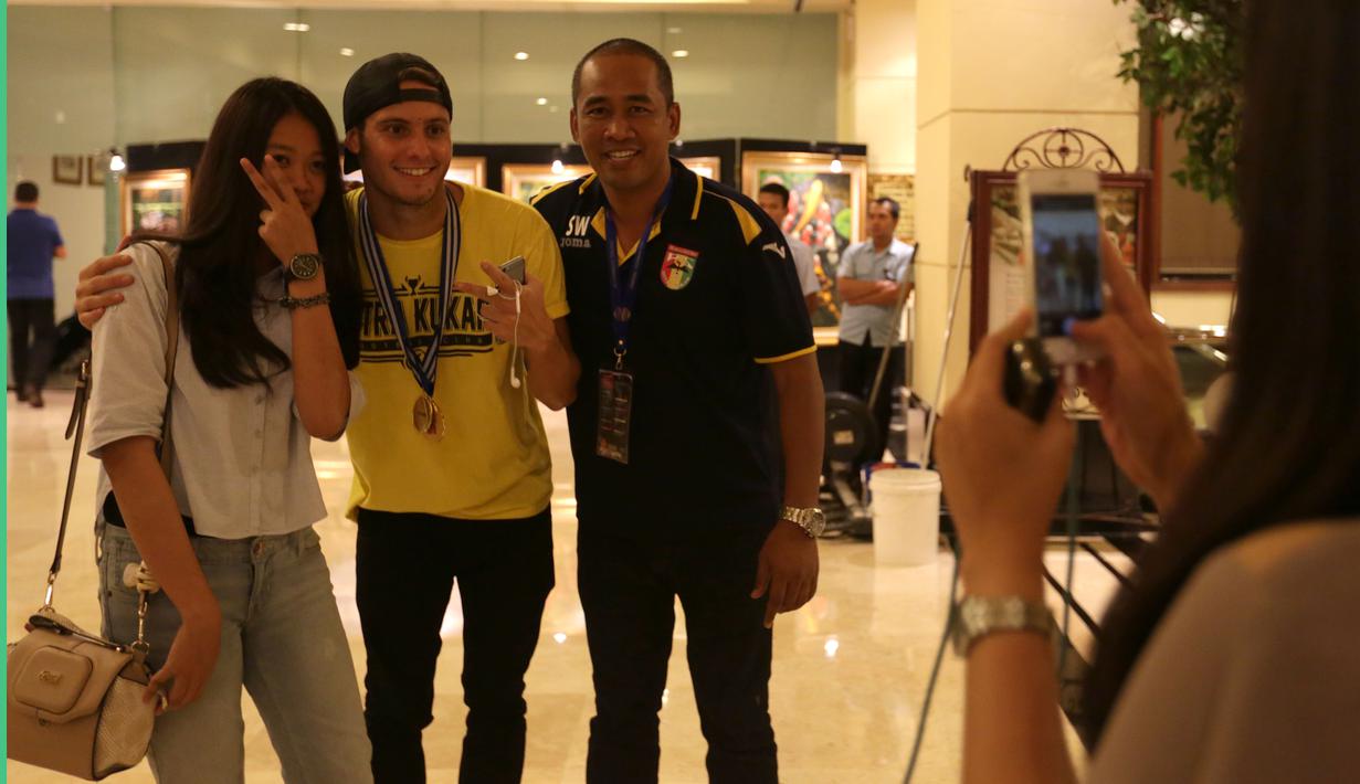 Pemain Mitra Kukar, Patrick Cruz, menjadi pemain yang paling sering diajak berfoto oleh suporter wanita saat tiba di Hotel Sultan, Jakarta, seusai menjuarai Piala Jenderal Sudirman, Minggu (24/1/2016). (Bola.com/Arief Bagus)