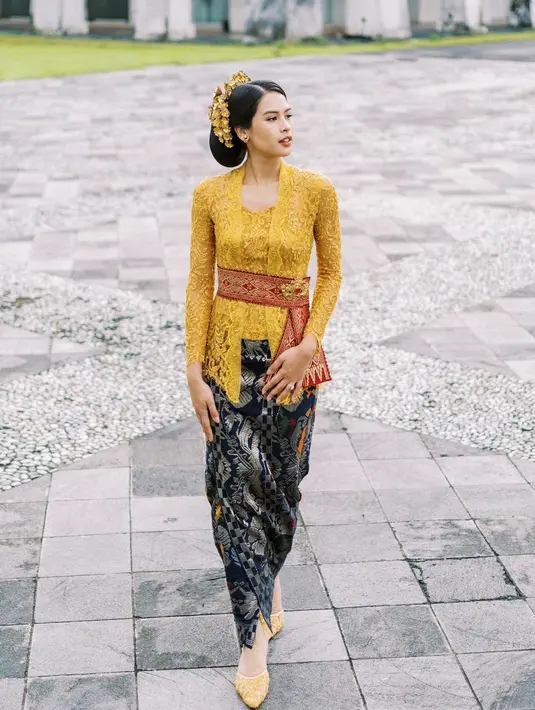 Pesona Maudy Ayunda dibalut kebaya brokat modern berwarna kuning. Kebaya ini memiliki desain klasik yang membalut tubuh Maudy Ayunda dengan amat apik. Padu padan wastra berwarna biru gelap semakin menyempurnakan penampilan Maudy secara keseluruhan di sini. [Foto: Instagram/maudyayunda]