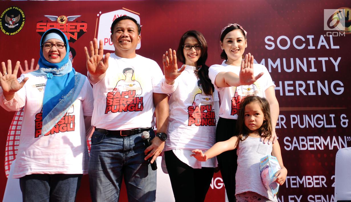 Kasatgas Saber Pungli, Komjen Pol Dwi Prayitno (kedua kiri) bersama Komisioner KPAI,  Retno Listyarti (kiri) membuat lambang penolakan pungli saat  social community gathering di Jakarta, Minggu (17/9). (Liputan6.com/Helmi Fithriansyah) 