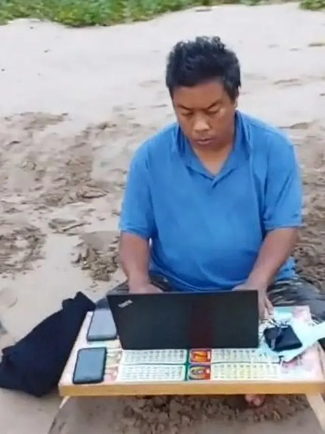 Demi Turuti Anak dan Istri Liburan, Pria ini Bawa Laptop dan Meja Kerja ke Pantai