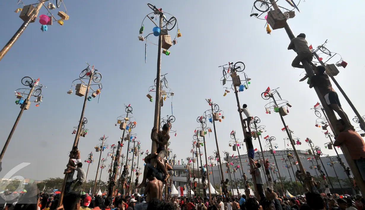 Sejumlah warga berebut memanjat pada lomba Panjat Pinang Kolosal dalam rangka merayakan HUT RI ke-70 di Pantai Karnaval, Ancol, Jakarta, Senin (17/8). Sebanyak 124 batang pinang disediakan dengan berbagai ragam hadiah. (Liputan6.com/Herman Zakharia)