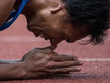 Atlet Jawa Tengah, Ega Rizki Firmanto, melakukan selebrasi usai memenangi nomor 200 meter T +54 putra pada Peparnas XV di Stadion Gelora Bandung Lautan Api, Bandung, Kamis (20/10/2016). (Bola.com/Peksi Cahyo) 