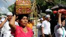 Umat Hindu membawa sesajen sebelum berdoa saat perayaan Kuningan di sebuah pura di Pulau Serangan, Denpasar, Bali, Sabtu (20/2). Kuningan merupakan hari terakhir dari perayaan Galungan. (AFP PHOTO/SONNY Tumbelaka)