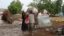 Sejumlah Warga membawa barang miliknya melintasi banjir setelah hujan deras melanda sebuah desa di provinsi Laut Merah Yaman, Houdieda, Jumat,  15 April 2016. (REUTERS/Abdul Jabbar Zeyad)