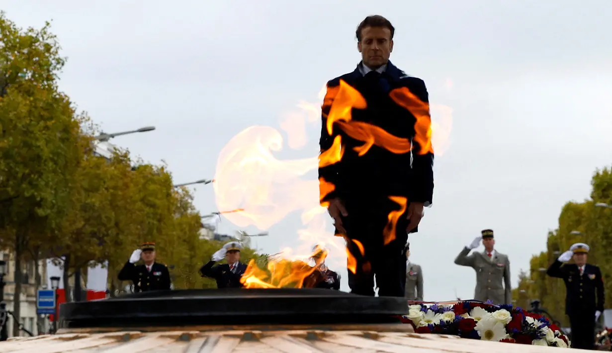 Presiden Prancis Emmanuel Macron berdiri di Makam Prajurit Tak Dikenal selama upacara di Arc de Triomphe, Paris, Prancis, 11 November 2022. Upacara ini digelar untuk menandai peringatan 104 tahun Gencatan Senjata 11 November 1918 yang mengakhiri Perang Dunia I. (Gonzalo Fuentes/Pool via AP)