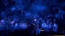 Orang-orang mengunjungi "Hutan Bercahaya" di Taman Descanso, Los Angeles, Senin (17/12). Dengan tema Enchanted: Forest of Light, pengunjung bisa melihat atraktif lampu dan karya seni ilumnasi dengan cahaya di taman tersebut. (Frederic J. BROWN / AFP)