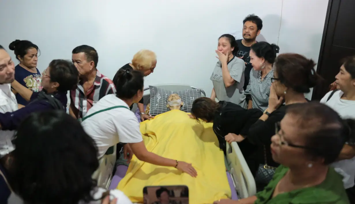 Sebelum jenazah diberangkatkan ke RS Dharmais untuk disemayamkan, pihak keluarga dan para pelayat lainnya berdiri di sisi mendiang dan berdoa bersama. Tentunya, tak kuasa air mata jatuh di pelupuk mata para pelayat. (Adrian Putra/Bintang.com)