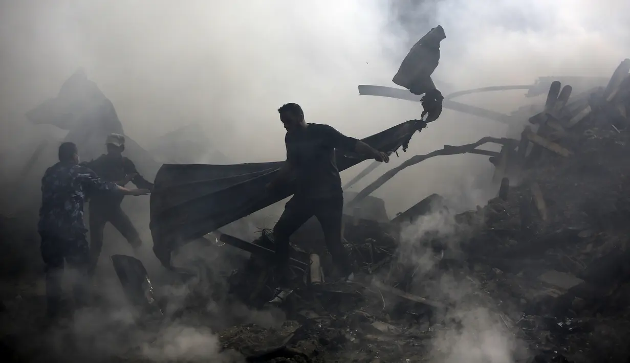 Warga memadamkan api yang membakar pasar di kamp pengungsi Nuseirat, Jalur Gaza, Palestina, Kamis (5/3/2020). Kebakaran menewaskan 11 orang dan 53 lainnya luka-luka. (MOHAMMED ABED/AFP)