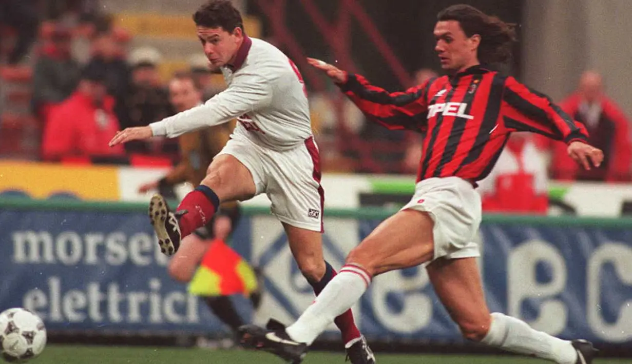 Bek AC Milan Paolo Maldini berusaha menghalau bola tendangan pemain Bordeaux Anthony Bancarel saat bertanding pada perempat final Piala UEFA pada 5 Maret. (AFP Photo/Gerard Julien)