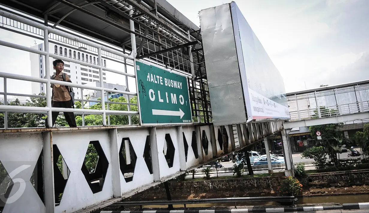 Seorang siswa menyeberang menggunakan Jembatan Penyeberangan Orang (JPO) di kawasan Hayam Wuruk Jakarta, Rabu (28/9). Menyusul robohnya JPO di Pasar Minggu, Pemprov DKI bakal membuat Pergub larangan papan iklan dipasang di JPO (Liputan6.com/Faizal Fanani)