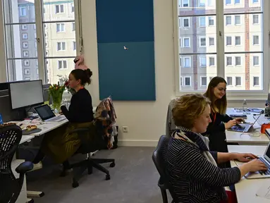 Sejumlah karyawan berada di meja kerja mereka pada hari pembukaan kantor baru raksasa mesin pencari internet, Google, di Berlin, Selasa (22/1). Google kembali membuka kantor cabang yang baru di ibu kota Jerman tersebut. (Photo by Tobias SCHWARZ / AFP)