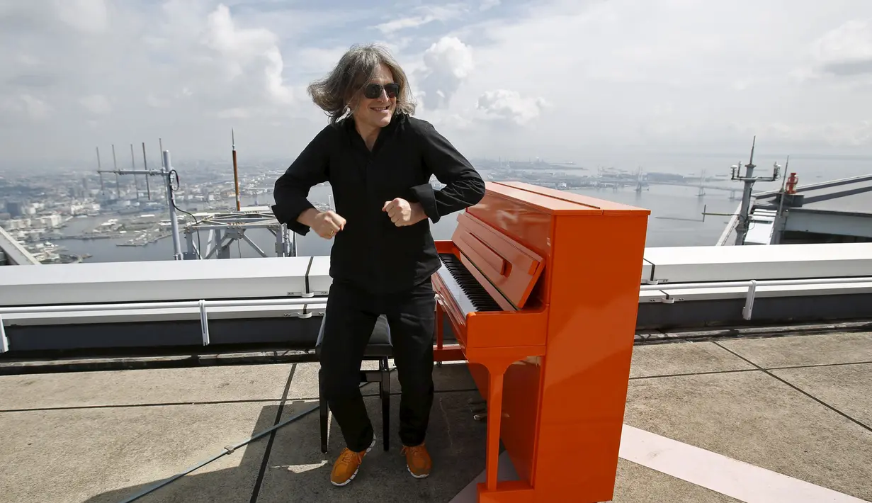 Musisi asal Jerman, Stefan Aaron menggelar `Orange Piano Tour` di Jepang, Jumat (4/9/2015). Stefan tampak bergaya dengan Piano orangenya. (REUTERS/Yuya Shino)