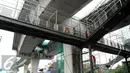 Pekerja menyelesaikan pembangunan jembatan penyeberangan orang jalan layang bus Transjakarta koridor XIII Ciledug-Tendean di kawasan Mayestik Jl. Kyai Maja, Jakarta Selatan, Rabu (2/11). (Liputan6.com/Gempur M. Surya)